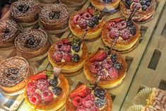 pastries and desserts on display in a glass case at a pastry shop window