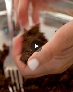 a person holding a piece of chocolate cake in their hands