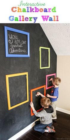 two children are playing with chalkboards on the wall