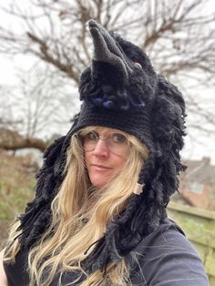 a woman wearing a knitted hat with an animal's head on top of it