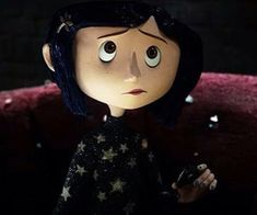 an animated doll with stars on it's body and black hair, holding a cell phone in her hand