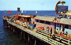 people are standing on the pier by the water