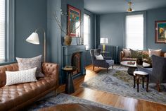 a living room with blue walls and leather furniture