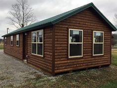 a small log cabin sitting in the middle of a field