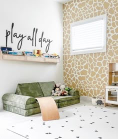 a child's playroom with giraffe wallpaper and green couches