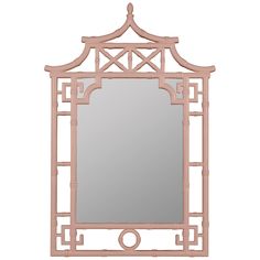 a mirror that is sitting on top of a table with a light pink frame and an ornate design