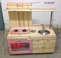 a toy kitchen made out of wood with instructions on how to build it and what to put in the sink