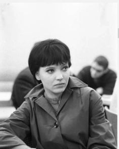 a black and white photo of a woman sitting at a table