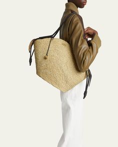 Loewe "Paseo" basket tote bag in raffia and leather     Rolled shoulder straps with Anagram pebble accent     Zip top closure     Interior, one slip pocket     Approx. 12.5"H x 22.6"W x 5.5"D    Made in Spain Designer Straw Tote Bag With Braided Handles, Designer Straw Shoulder Bag For Shopping, Designer Bucket Bag With Leather Handles In Natural, Designer Natural Bucket Bag With Leather Handles, Designer Straw Tote Bag With Adjustable Strap, Designer Natural Bucket Bag For Travel, Designer Natural Color Tote Bucket Bag, Designer Straw Bag With Adjustable Strap In Natural Color, Designer Straw Bag With Adjustable Strap