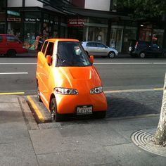 an orange car is parked on the side of the street