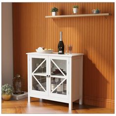 a small white cabinet with glass doors and shelves on the wall next to a wooden floor