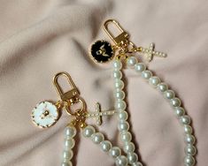 two white and black beaded bracelets with charms on top of each other next to a clock