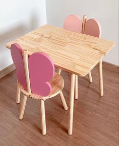 a wooden table and chairs with pink hearts on them