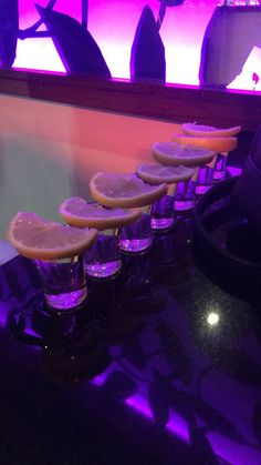 a row of lemon slices sitting on top of a counter next to a purple light