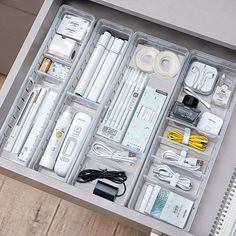 an open drawer containing electronic devices and cords