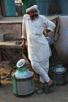 a man is standing next to two buckets