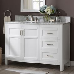 a white bathroom vanity with two sinks and a large mirror over the sink that has flowers on it