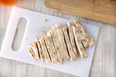 sliced chicken sitting on top of a cutting board