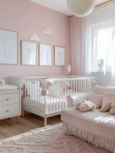 a baby's room with pink walls and white furniture