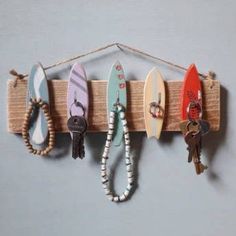 several surfboards are hanging on a wall with keychains attached to the hooks