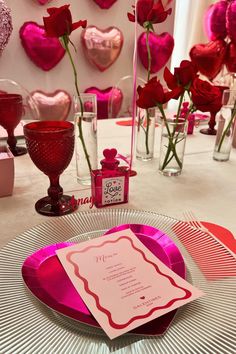 the table is set with pink and red decorations