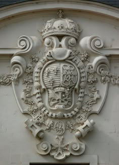 an ornate coat of arms and crown on the side of a building