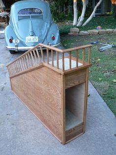 an old car is parked in front of a house with a wooden staircase leading up to it