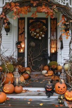 a front porch decorated for halloween with pumpkins and candles