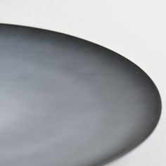 a black plate sitting on top of a white table