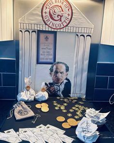 a table topped with lots of gold coins next to a sign that says the bank of england