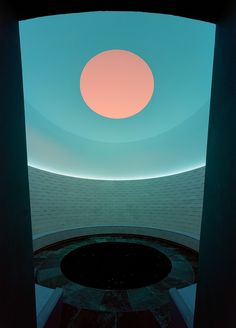 an empty room with a round light in the center and blue sky above it at night