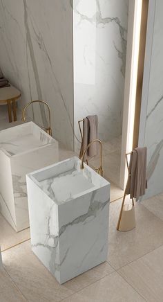 a bathroom with marble walls and flooring next to two sinks in the same room