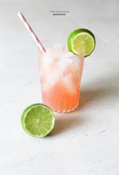 a drink with limes and a straw in it