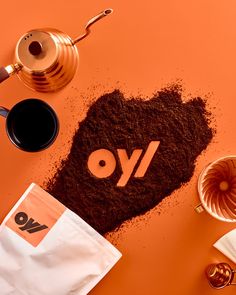 the word yo spelled out in dirt next to coffee and other items on an orange surface