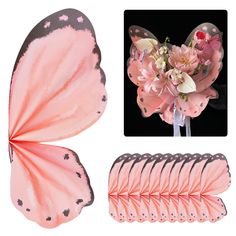 a pink butterfly with black spots on it's wings and flowers in the back