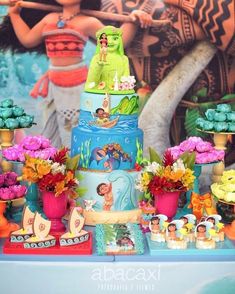 there is a cake on the table with flowers and other items around it that are colorful