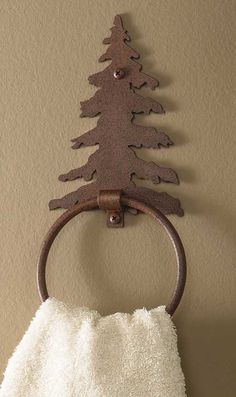 a towel ring with a tree on it hanging from the wall next to a towel rack