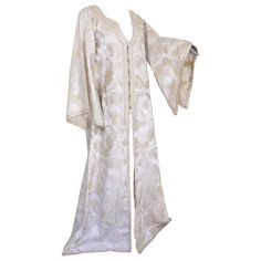 Elegant Moroccan white ivory and old brocade kaftan embroidered with gold trim threads. Size L to XL circa 1980s. This long maxi dress kaftan is embroidered and embellished entirely by hand. One of a kind evening Moroccan Middle Eastern gown. The kaftan features a traditional neckline and embellished sleeves. In Morocco, fashion preserves its traditional style inherited from great civilizations that found their way to Northwest Africa, such as the Ottomans and the Moors. Moroccan fashion has bee Brocade Kaftan, Royal Attire, Stage Style, Morocco Fashion, Embellished Sleeves, Chinese Embroidered, Moroccan Kaftan, Dress Kaftan, Moroccan Fashion