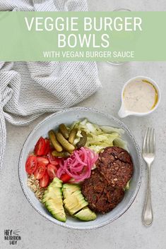 a white plate topped with meat and veggies next to a bowl of salad