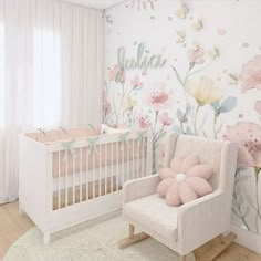 a baby's room decorated in pastel colors with flowers on the wall and a rocking chair