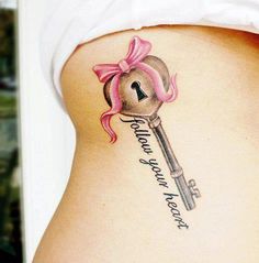 a woman's stomach with a key tattoo on it