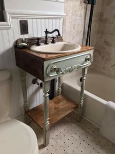 a bathroom with a sink, toilet and bathtub in the corner next to it