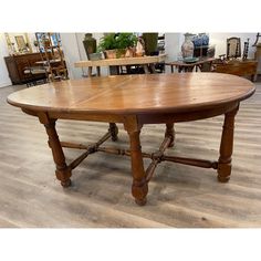 an oval wooden table sitting on top of a hard wood floor