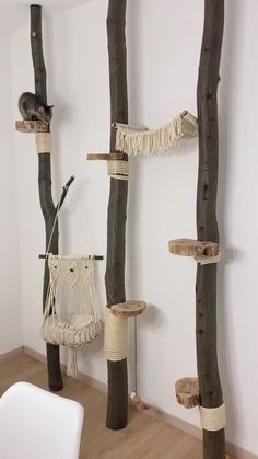 the cat tree is made out of wood and has two hammocks hanging from it's sides