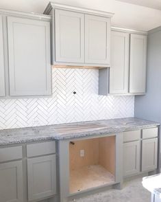 an empty kitchen with white cabinets and marble counter tops in the process of remodeling