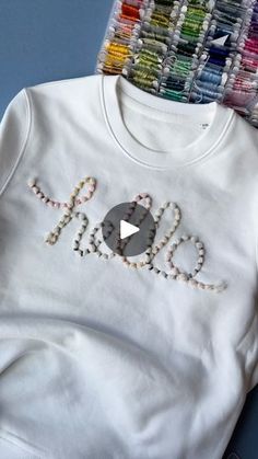 a t - shirt with the word love on it next to some crayons