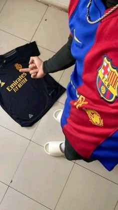 a person sitting on the floor with a soccer jersey in front of their back pocket