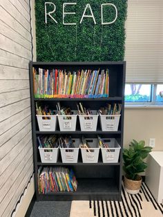 a bookshelf filled with lots of books in front of a sign that reads read