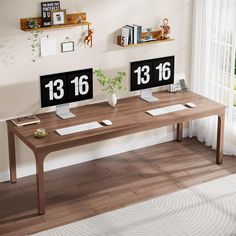 two computer desks sitting on top of a hard wood floor next to a window