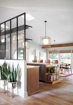 an open concept kitchen and dining room with wood flooring, white walls and wooden floors